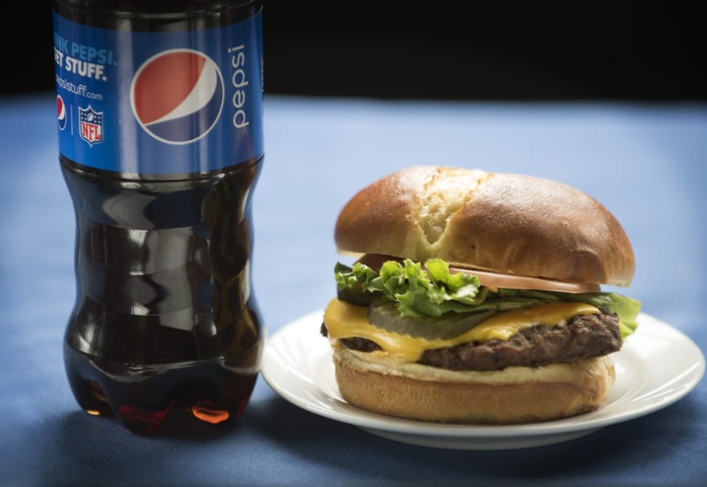 photo of a cheeseburger and pepsi soda